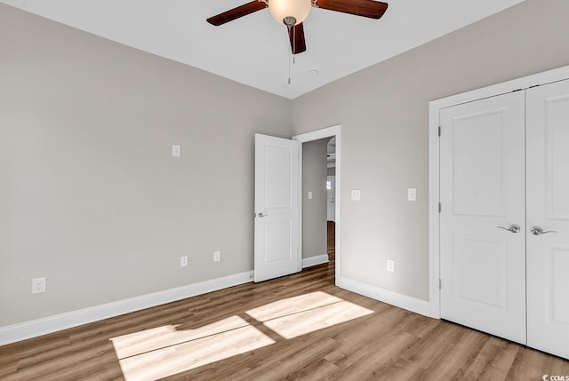 unfurnished bedroom with a closet, a ceiling fan, baseboards, and wood finished floors