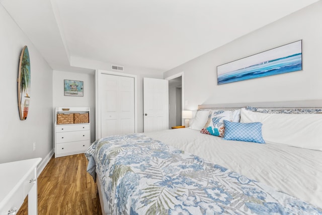 bedroom with a closet and dark hardwood / wood-style floors