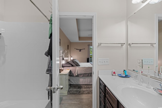 bathroom with vanity, hardwood / wood-style floors, and shower / washtub combination