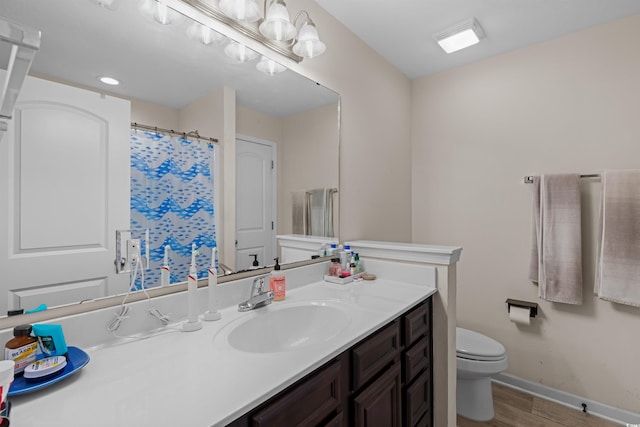 bathroom with hardwood / wood-style floors, toilet, and vanity