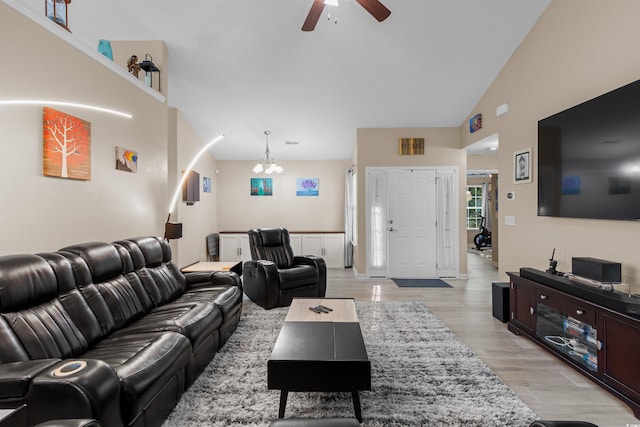 living room featuring high vaulted ceiling, ceiling fan with notable chandelier, and light hardwood / wood-style floors