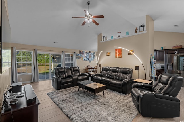 living room featuring high vaulted ceiling, light hardwood / wood-style flooring, and ceiling fan