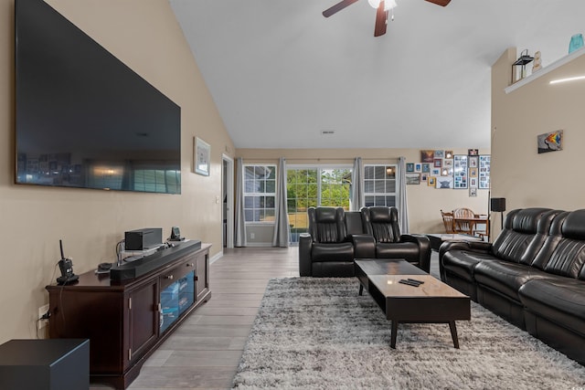 living room with light wood-type flooring, high vaulted ceiling, and ceiling fan