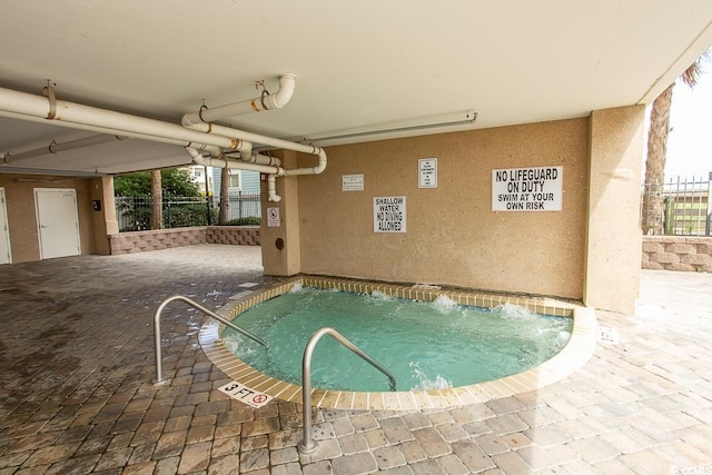 view of swimming pool featuring an indoor hot tub