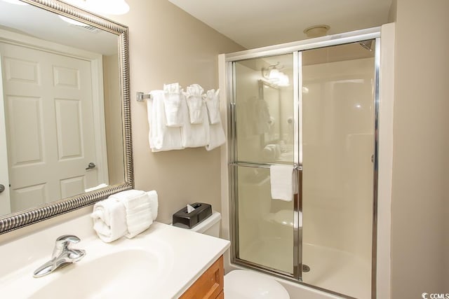 bathroom featuring vanity, toilet, and an enclosed shower