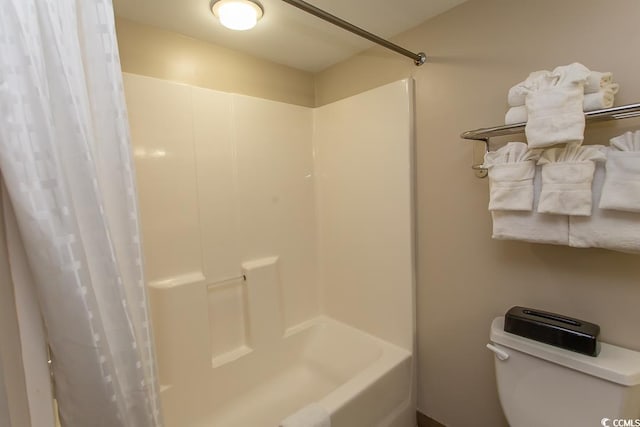 bathroom featuring shower / tub combo with curtain and toilet