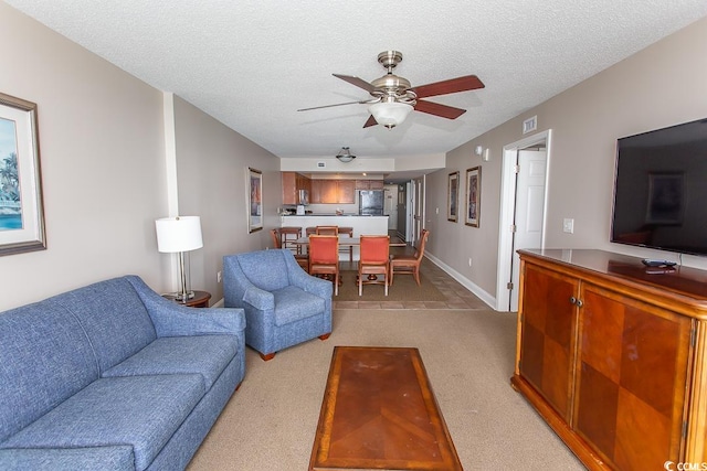 carpeted living room with ceiling fan and a textured ceiling