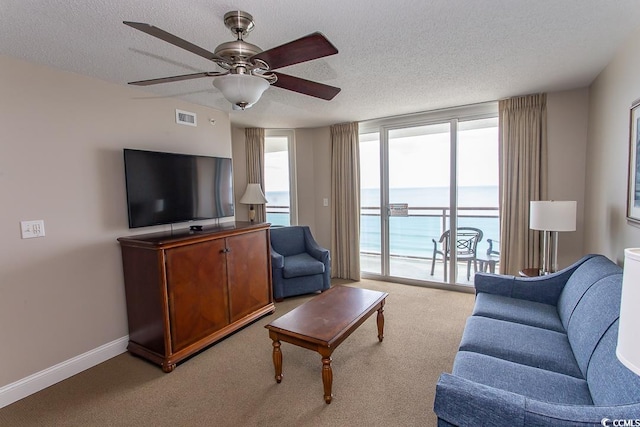 carpeted living room with a textured ceiling and ceiling fan