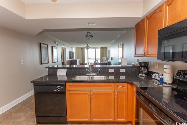 kitchen featuring light tile patterned floors, dark stone counters, sink, and black appliances