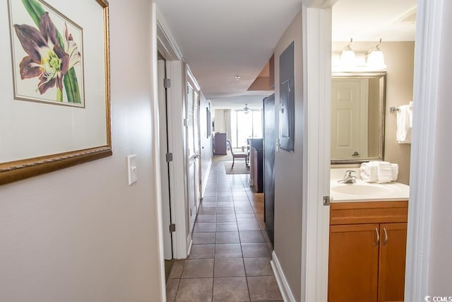 hallway with dark tile patterned flooring and sink