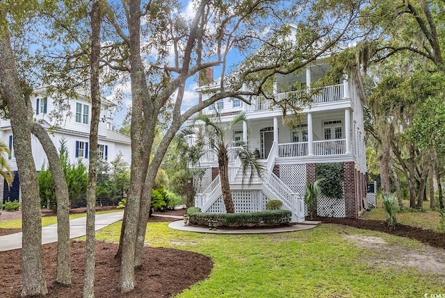 view of front of house with a front lawn, covered porch, and a balcony