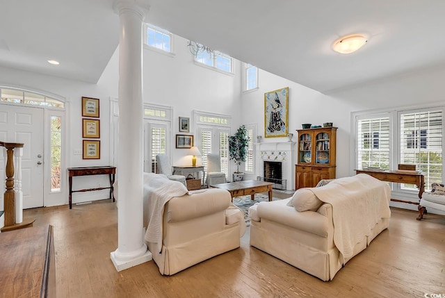 living room with plenty of natural light, a towering ceiling, and wood-type flooring