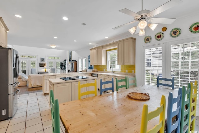 dining space featuring sink, light tile patterned floors, and ceiling fan