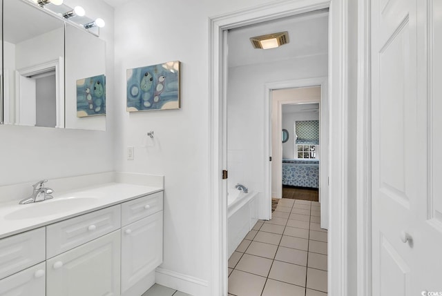 bathroom featuring tile patterned floors, tiled tub, and vanity