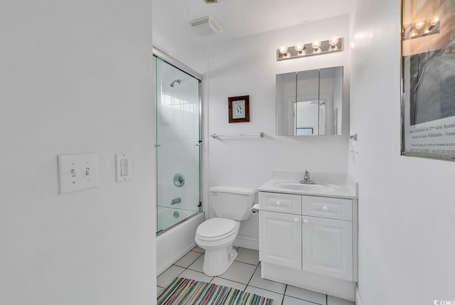 full bathroom featuring shower / bath combination with glass door, vanity, tile patterned flooring, and toilet