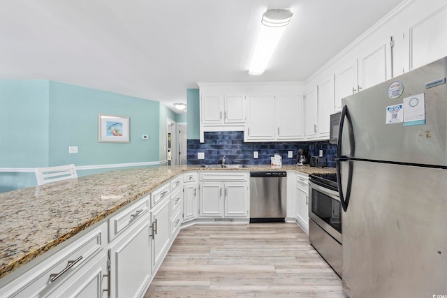 kitchen featuring white cabinets, backsplash, light hardwood / wood-style flooring, appliances with stainless steel finishes, and light stone countertops