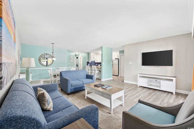 living room featuring light hardwood / wood-style floors and a chandelier