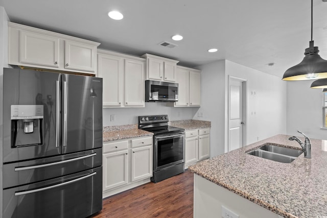 kitchen with white cabinetry, stainless steel appliances, sink, and light stone counters