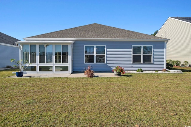 back of property with a sunroom and a lawn