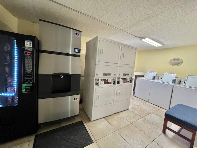 clothes washing area featuring stacked washer / drying machine, a textured ceiling, and light tile patterned floors