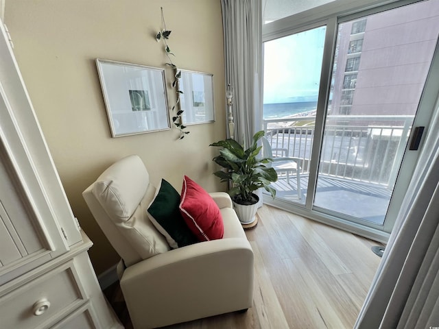 sitting room with a water view and light wood-type flooring