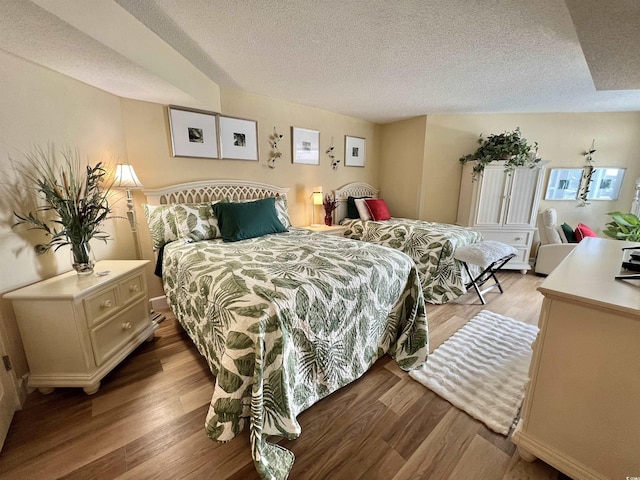 bedroom with light hardwood / wood-style flooring and a textured ceiling