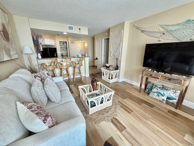 2504 N Ocean Blvd Unit 734, Myrtle Beach, SC 29577 - living area featuring wood finished floors, a textured ceiling, and bar