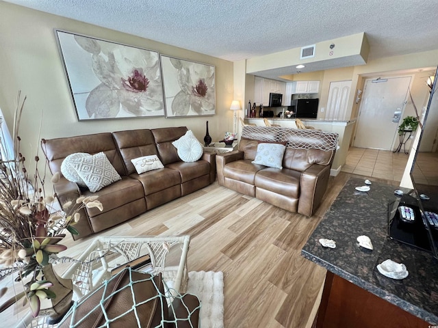 living room with light hardwood / wood-style flooring and a textured ceiling