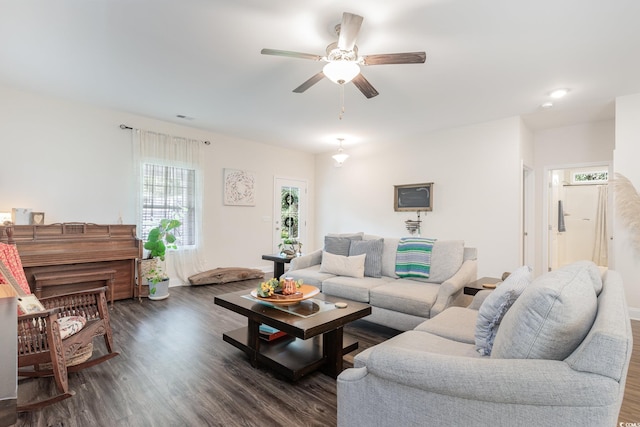 living room featuring dark wood-type flooring and ceiling fan