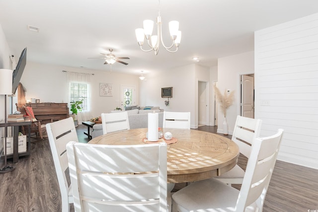 dining area with dark hardwood / wood-style flooring and ceiling fan with notable chandelier