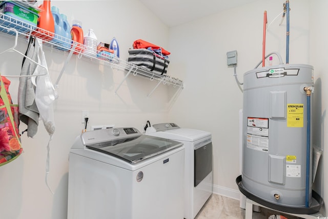 laundry room featuring washer and dryer, electric water heater, and light tile patterned floors