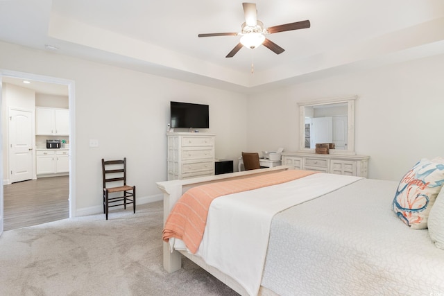 bedroom featuring light carpet, a raised ceiling, and ceiling fan