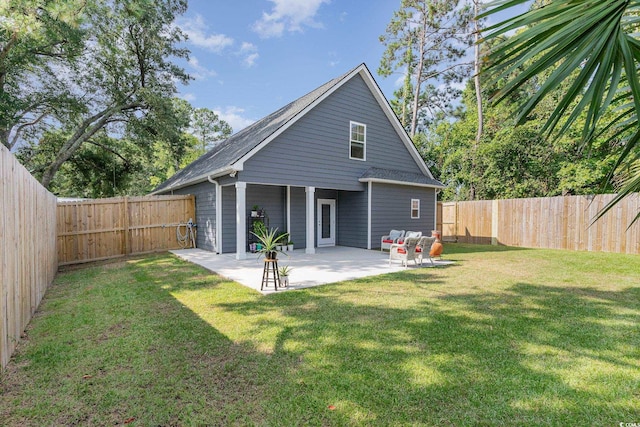 rear view of property with a yard and a patio