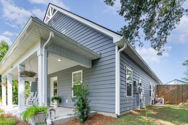 view of side of property with a porch and central AC unit