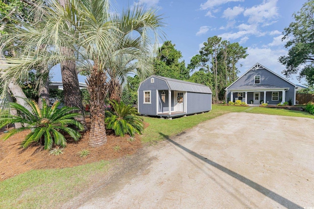 view of front of house with a storage unit and a front lawn