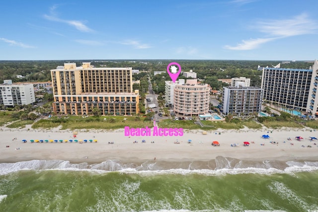 birds eye view of property featuring a water view and a beach view