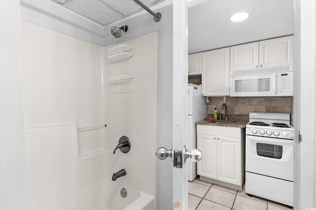 bathroom featuring tile patterned flooring, shower / washtub combination, vanity, and decorative backsplash