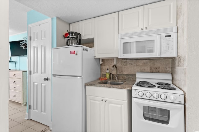 kitchen featuring sink, white appliances, light tile patterned floors, tasteful backsplash, and white cabinets