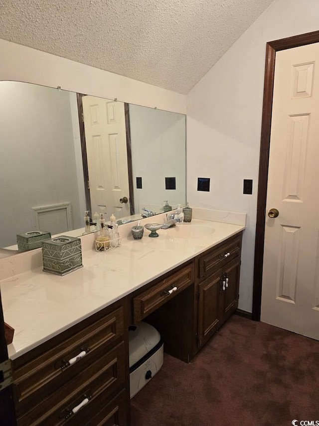 bathroom featuring vanity, a textured ceiling, and toilet