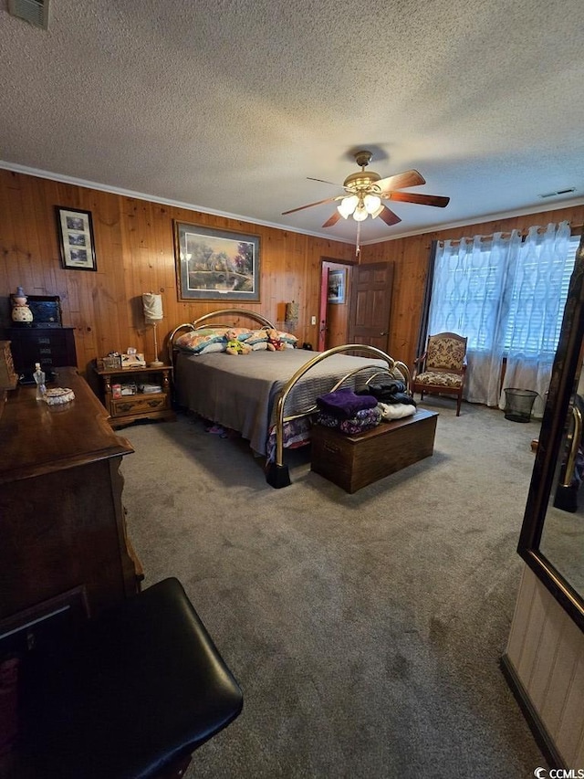 bedroom featuring wooden walls, ceiling fan, carpet floors, and a textured ceiling