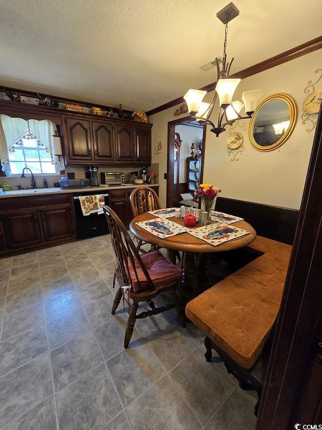 tiled dining area with a textured ceiling, ornamental molding, sink, and a chandelier