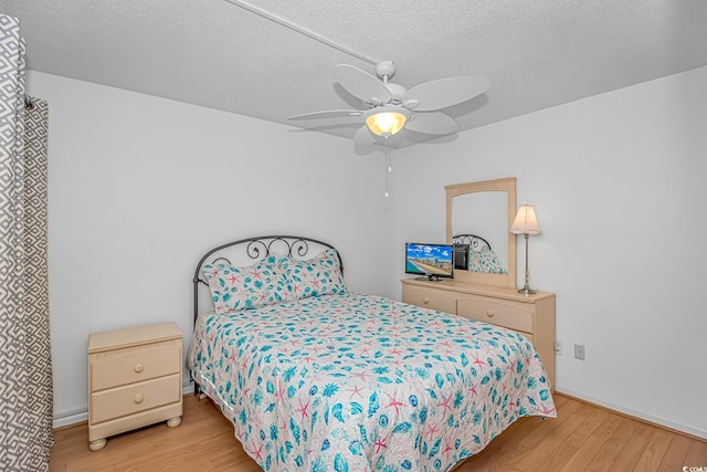 bedroom featuring ceiling fan, a textured ceiling, and light hardwood / wood-style flooring