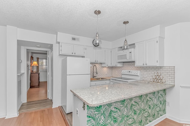 kitchen with decorative light fixtures, sink, white cabinets, kitchen peninsula, and white appliances