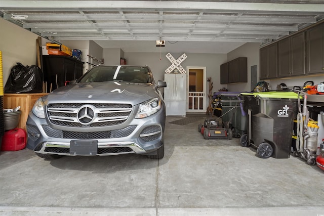 garage with a garage door opener, electric panel, and white refrigerator