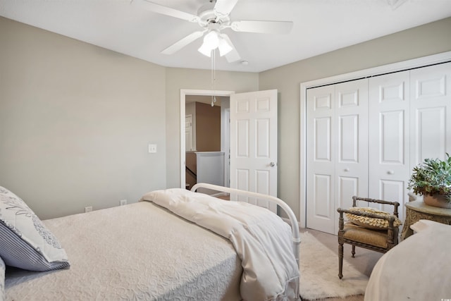 carpeted bedroom featuring ceiling fan and a closet