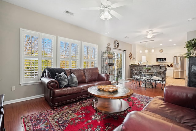 living room with ceiling fan and light hardwood / wood-style floors