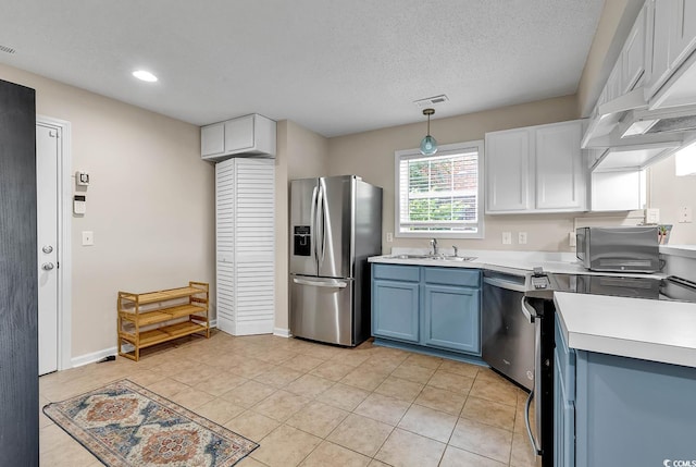 kitchen featuring visible vents, light countertops, stainless steel appliances, a sink, and blue cabinetry