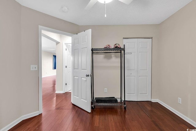 unfurnished bedroom with a textured ceiling, ceiling fan, and dark wood-type flooring