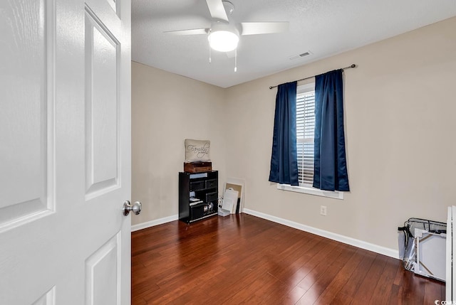 unfurnished room with a ceiling fan, baseboards, visible vents, and hardwood / wood-style floors