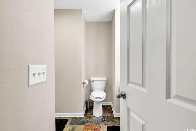 bathroom featuring a textured ceiling and toilet